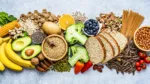 Overhead view of a large group of food with high content of dietary fiber arranged side by side. The composition includes berries, oranges, avocado, chia seeds, wholegrain bread, wholegrain pasta, whole wheat, potatoes, oat, corn, mixed beans, brazil nut, sunflower seeds, pumpkin seeds, broccoli, pistachio, banana among others. High resolution 42Mp studio digital capture taken with SONY A7rII and Zeiss Batis 40mm F2.0 CF lens